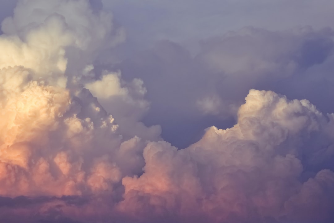 A cloudy sky with a pink and purple sky.