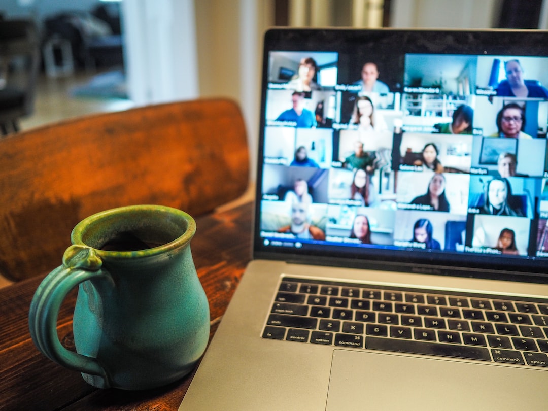 A laptop with a group of people on it on a table.