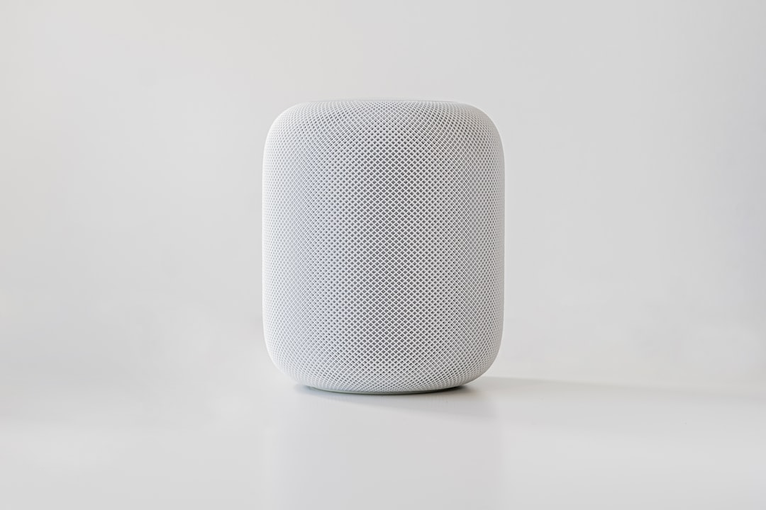 An apple homepod sitting on a white surface.