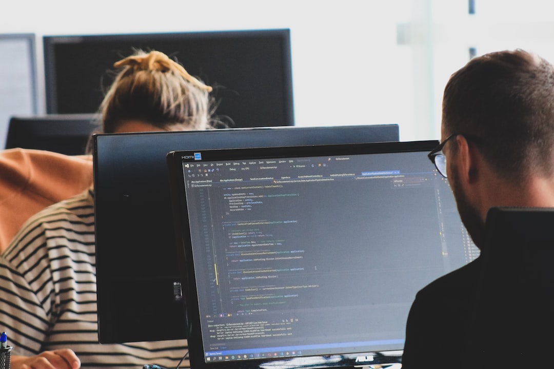 Two people working on computers in an office.