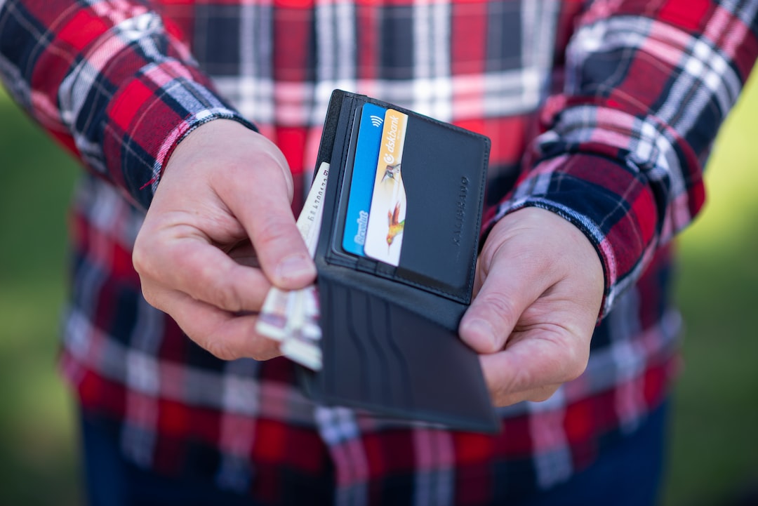 A man holding a wallet with credit cards in it.