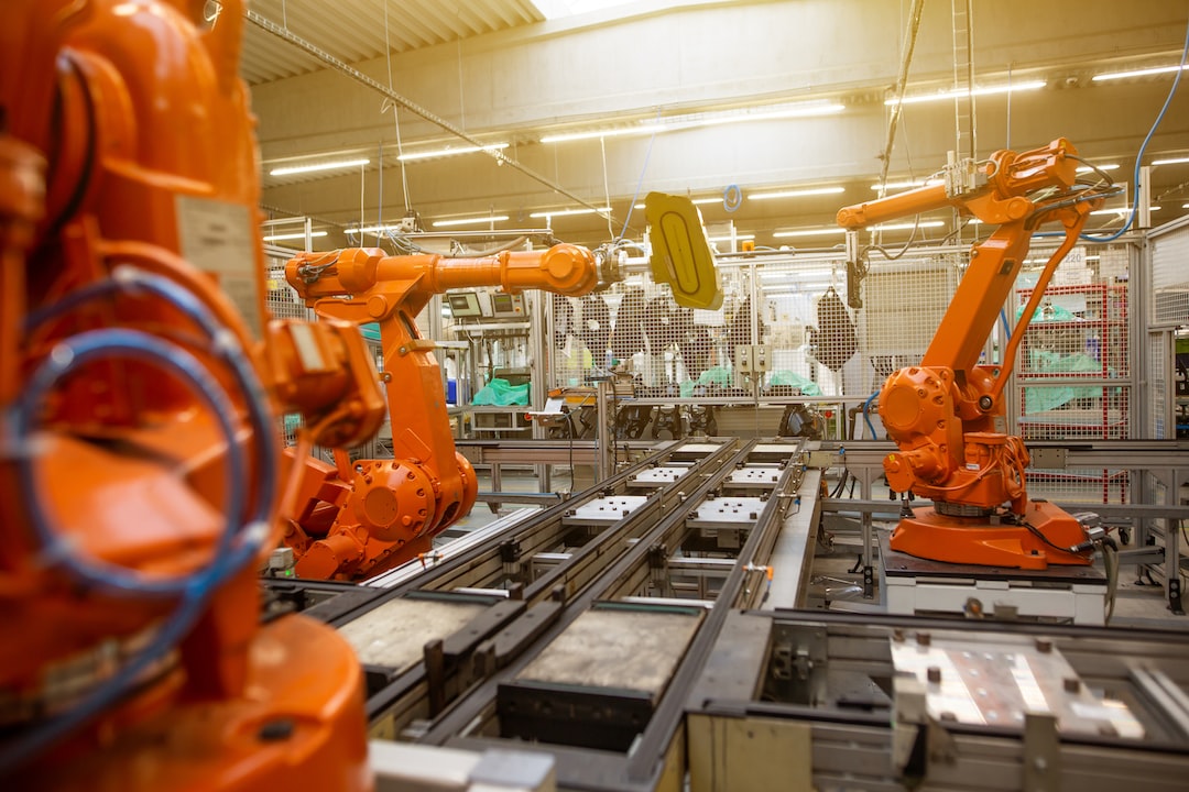 A factory with orange robots working in a factory.