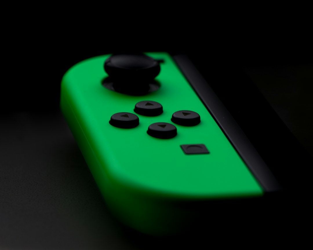 A green nintendo switch controller on a black background.