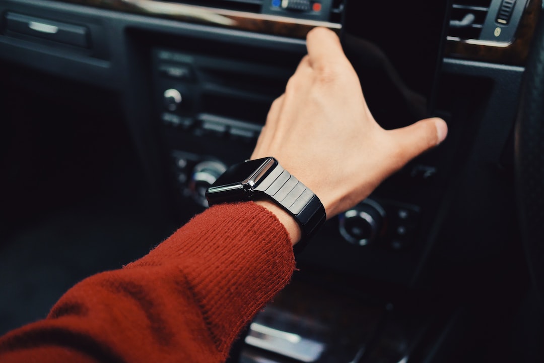 A person holding a smart watch in a car.