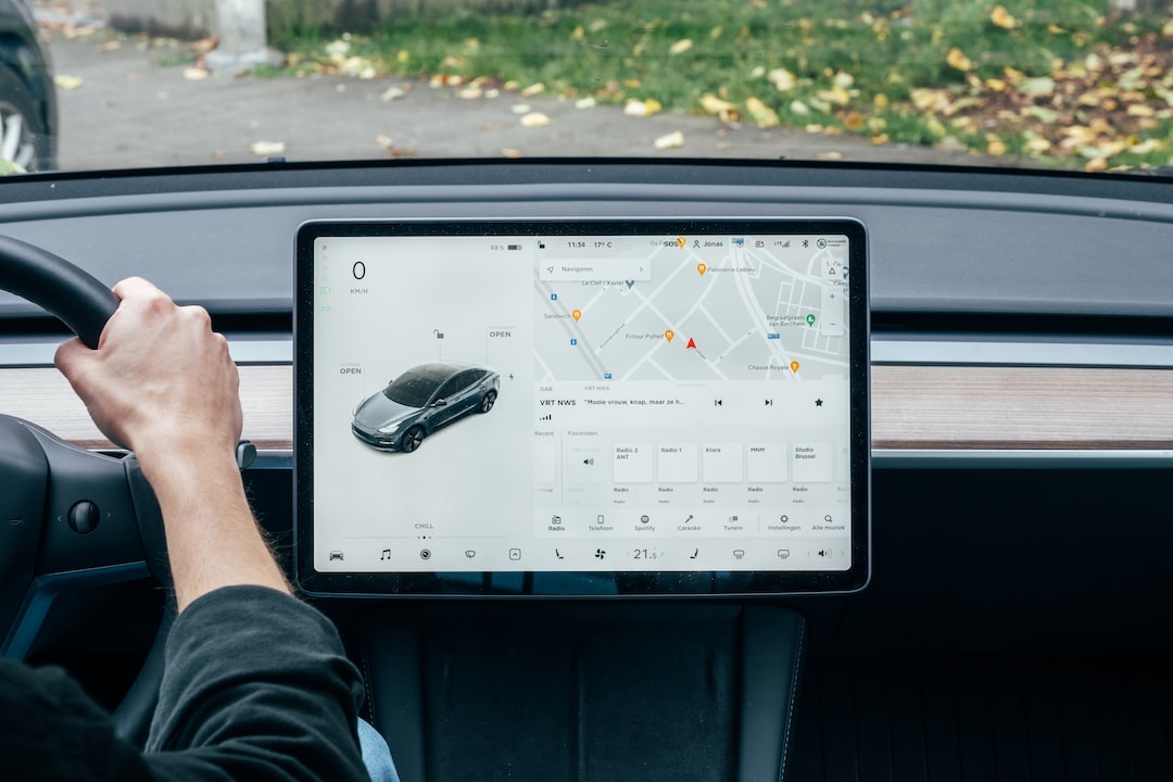 A person driving a tesla model s with a map on the dashboard.