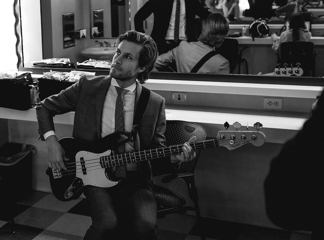 A man playing a bass in front of a mirror.