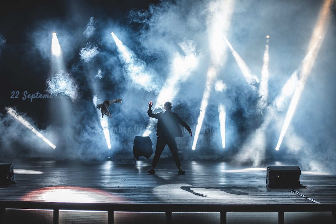 A man standing on a stage with smoke coming out of it.