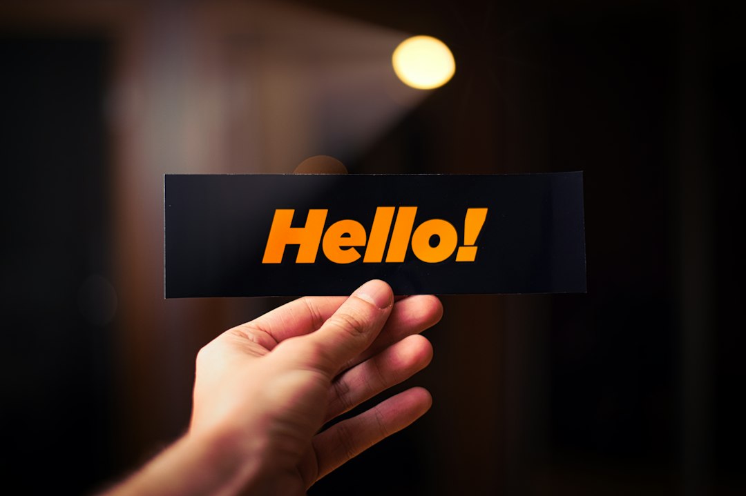 A person holding up a card with the word hello.