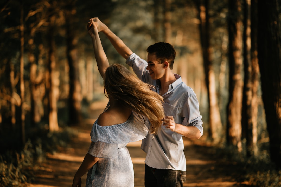 A man and woman dancing in the woods.