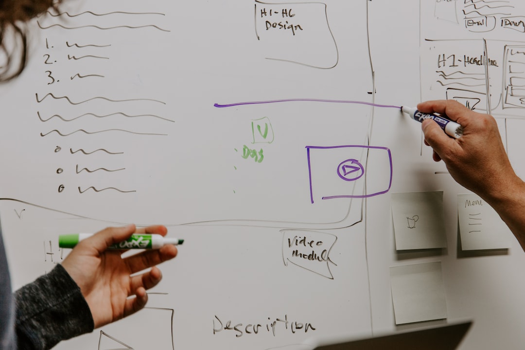 Two people writing on a whiteboard.