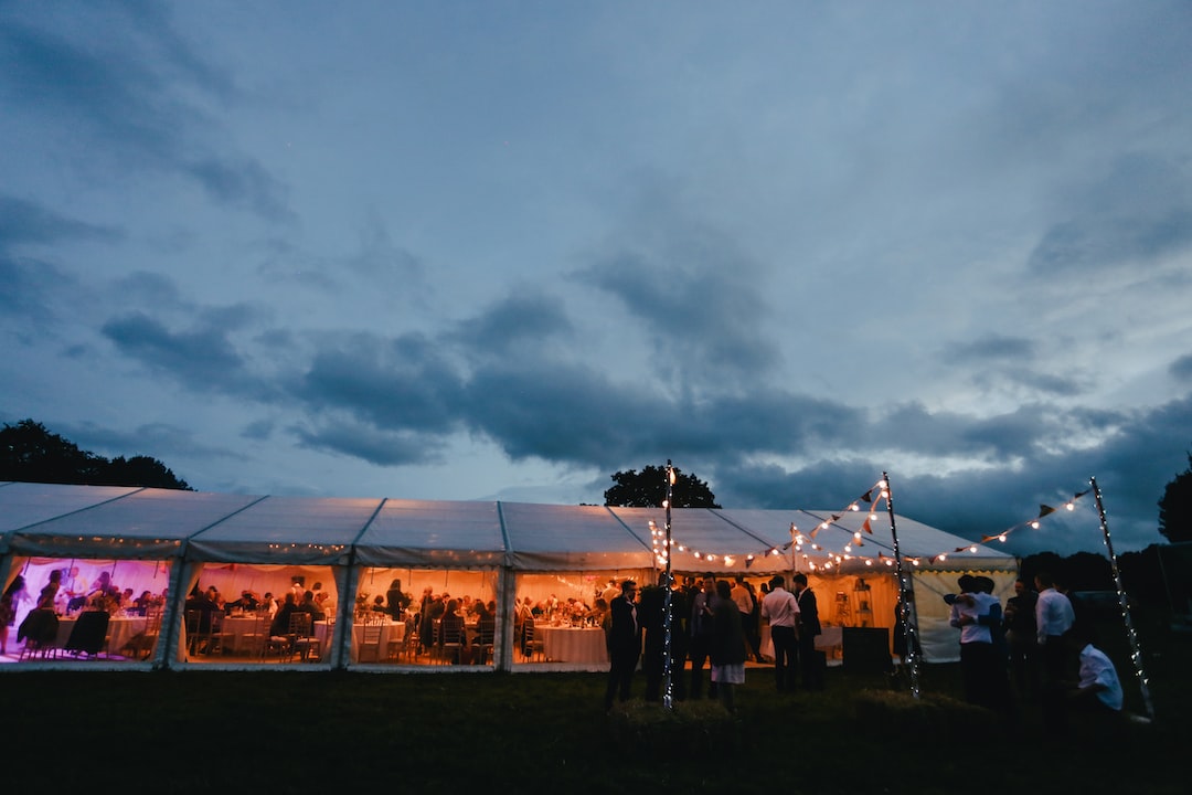 A wedding reception in a tent under a cloudy sky.