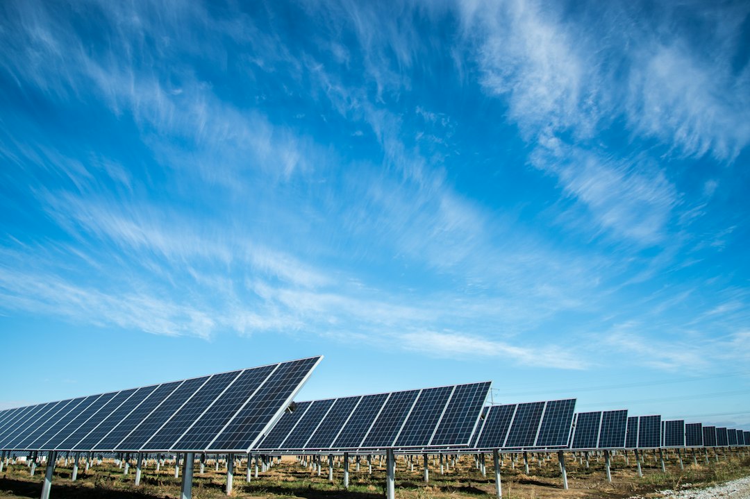 Solar panels in a field against a blue sky.