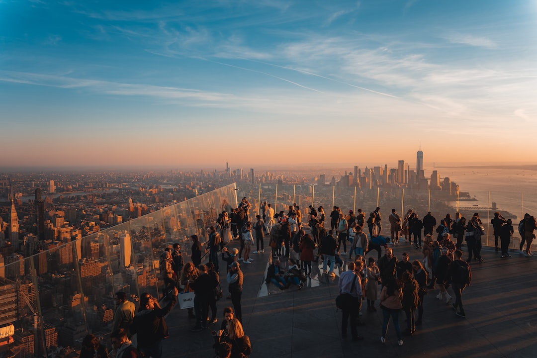 A group of people standing on top of a building at sunset.