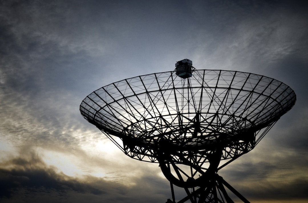 A satellite dish against a cloudy sky.